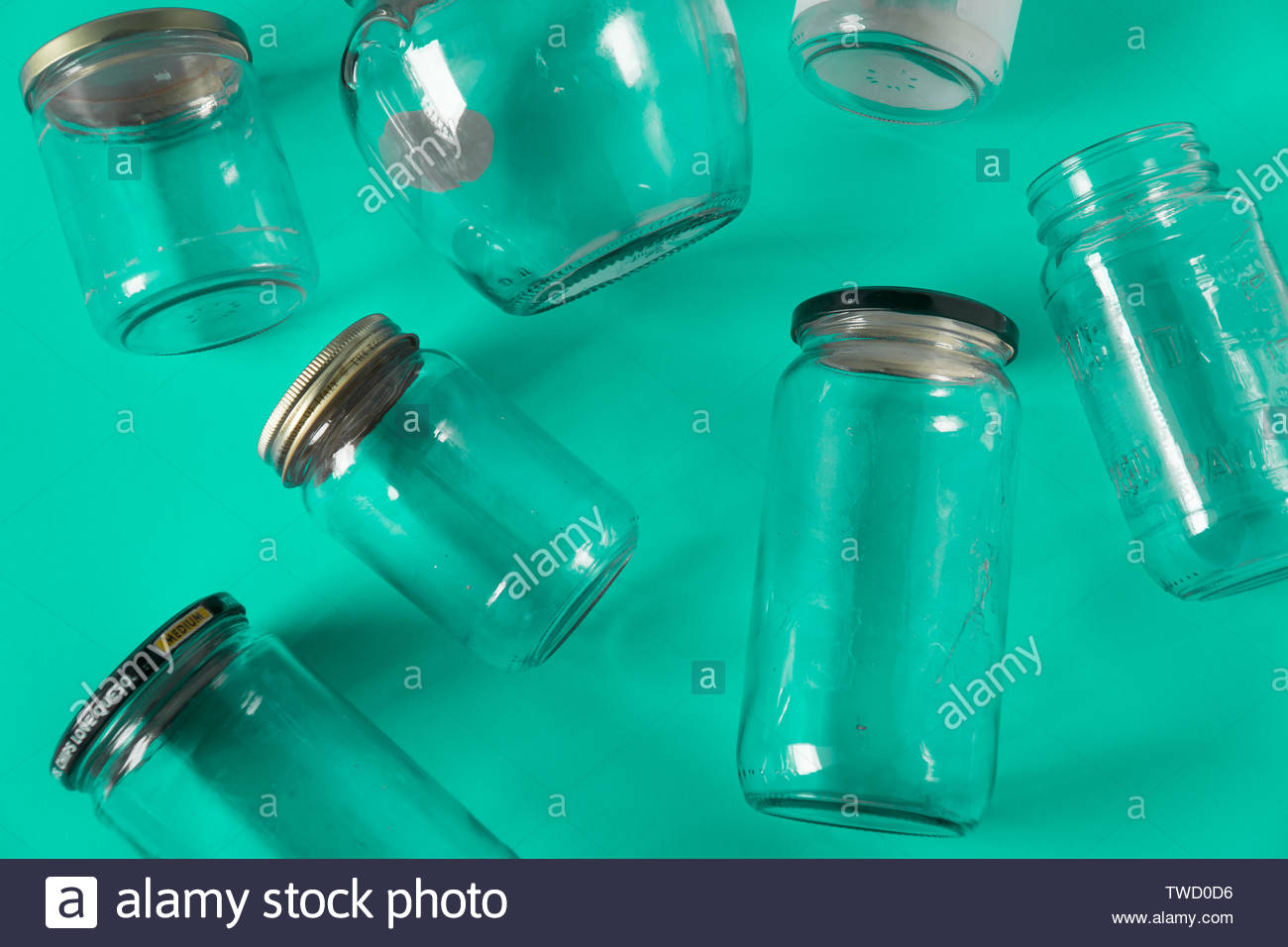 transparent glass jars with lids isolated on teal green background top view flat lay recycling concept for environmental awareness segregated recycl TWD0D6